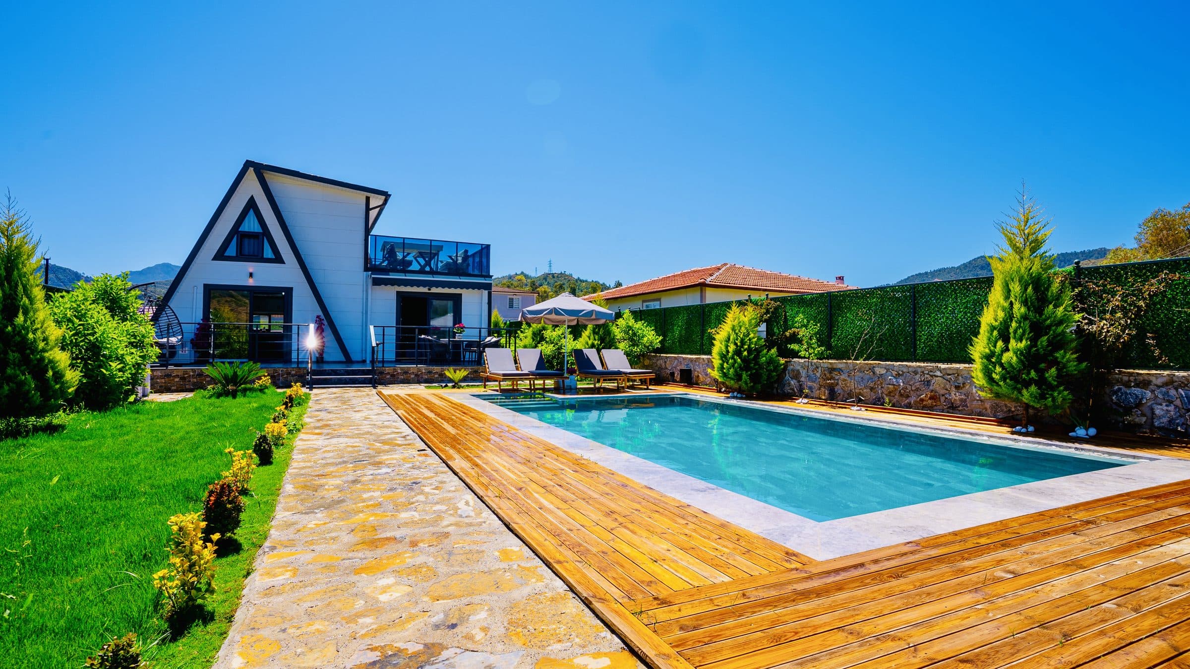 Villa Lojja dış görünüm — A-frame ev ve havuz